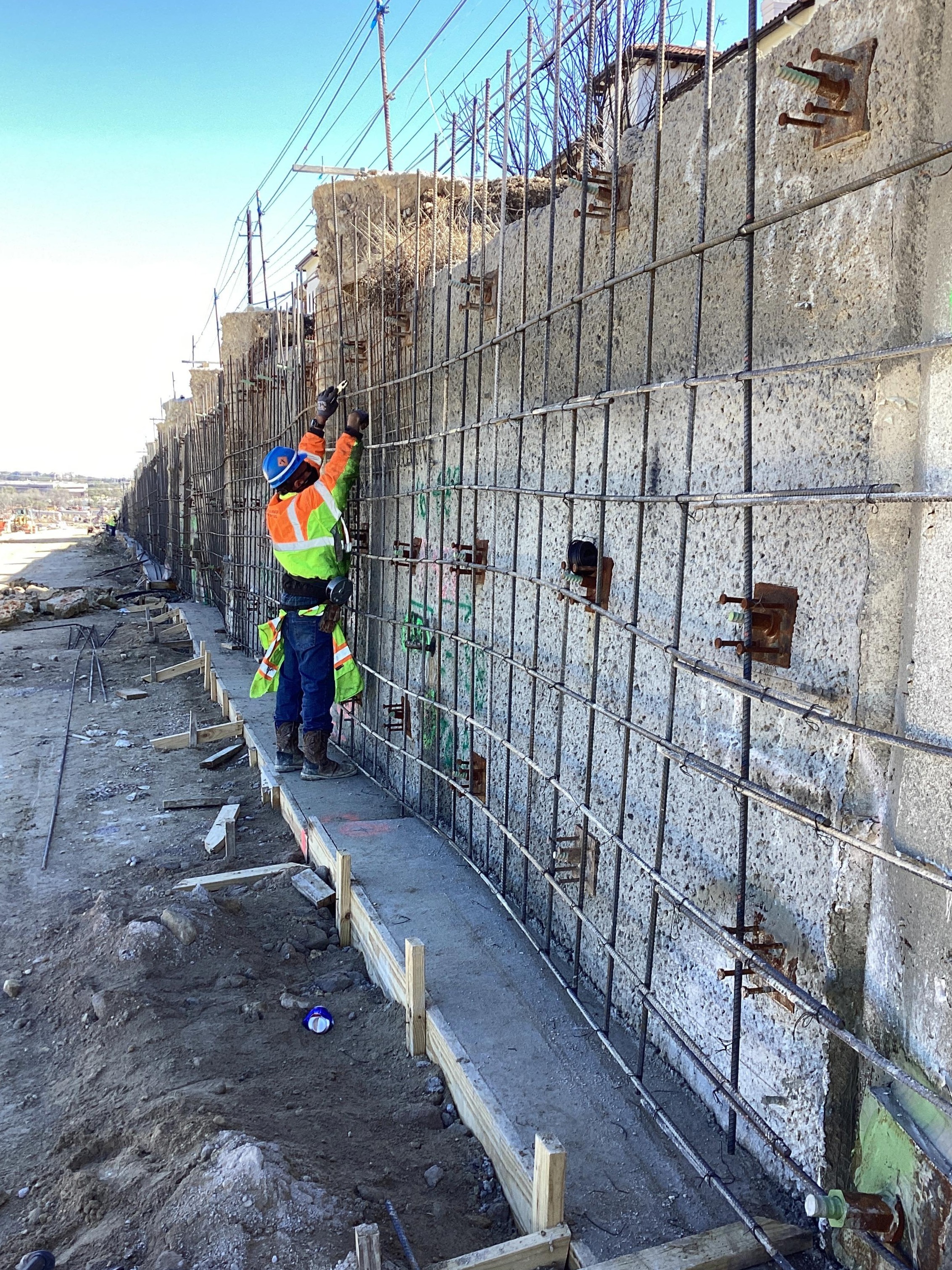 Crews adjust rebar for wall panel installations.
